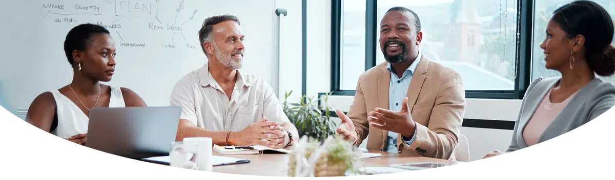 Four people sitting around a table in a meeting.